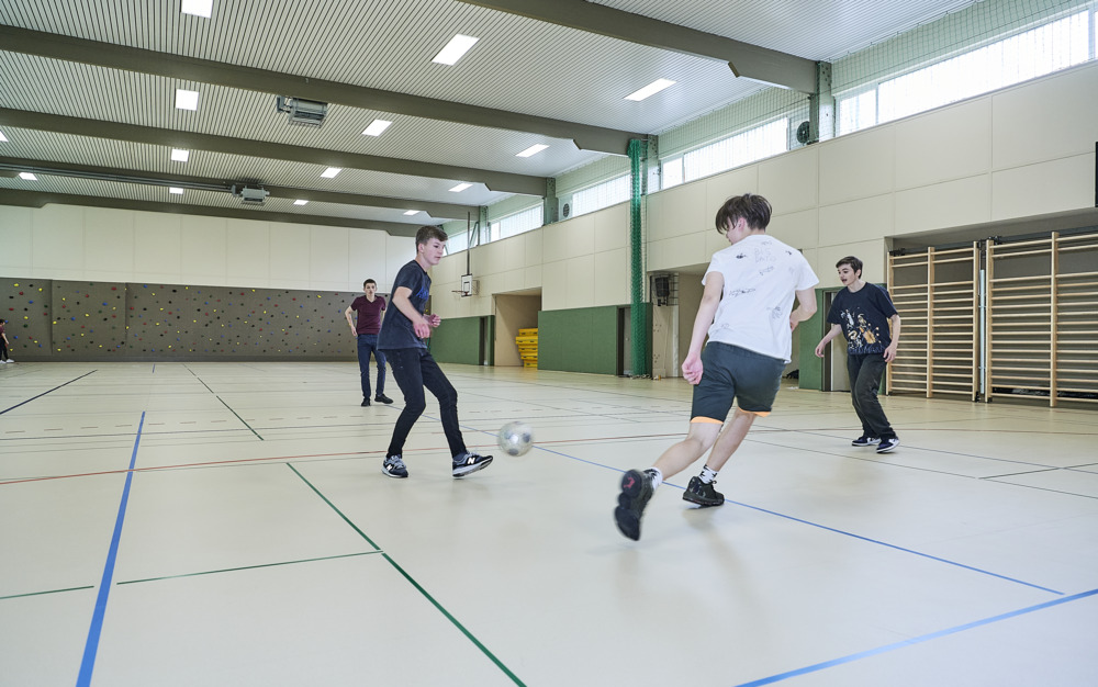 Kickende Jugendliche in Sporthalle auf noraplan sentica Sporthallenboden